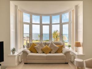 a living room with a couch in front of a large window at Babbacombe House in Torquay