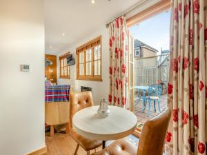 a room with a table and chairs and a balcony at Copse Lodge in Eling
