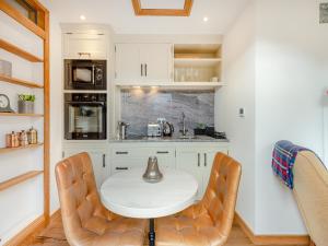 a kitchen with a table and two chairs at Copse Lodge in Eling