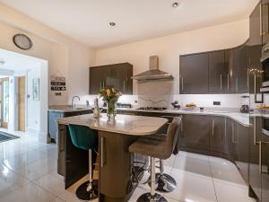 a kitchen with a center island with a vase of flowers on it at Babbacombe House in Torquay +31 photos