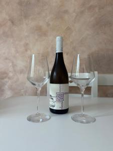 a bottle of wine and two wine glasses on a table at Green Oasis Budva in Prijevor