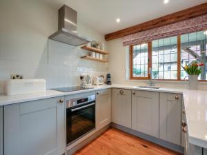 a kitchen with white cabinets and a sink at Keeds Barn in Arundel