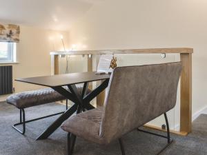 a wooden table with a chair and a desk at Kinneret Apartment in Silsden +10 photos