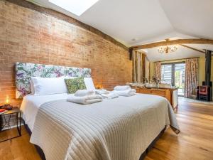 a bedroom with a large bed with towels on it at The Old Press - Uk50806 in Halesworth