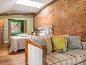a living room with a couch and a brick wall at The Old Press - Uk50806 in Halesworth +4 photos