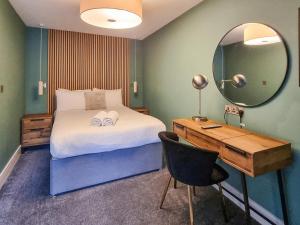 a bedroom with a bed and a desk and a mirror at Uk47853 - No 2B in Aberystwyth