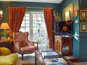 a living room with a tv and a chair at Russell Cottage in Flore