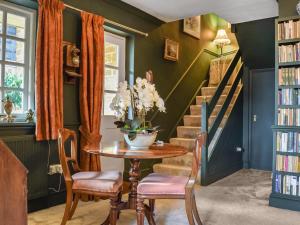 a dining room with green walls and a table and chairs at Russell Cottage in Flore