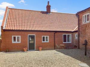 a red brick house with a door and a patio at The Dairy - Uk48866 in Aylsham