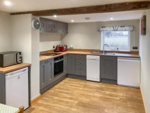 a kitchen with gray cabinets and white appliances at The Dairy - Uk48866 in Aylsham