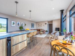 a kitchen and living room with a bar and chairs at Hayloft - Uk49529 in Buchlyvie