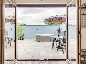 a patio with a table and an umbrella at Wisteria Lodge - Ukc5804 in Shelfanger