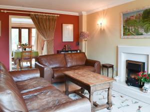 a living room with leather furniture and a fireplace at The Palm in Seasalter
