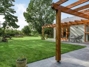a garden with a wooden pergola and a patio at North Farm Lodges in East Mersea