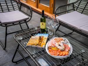 a table with a plate of food and a bottle of wine at North Farm Lodges in East Mersea