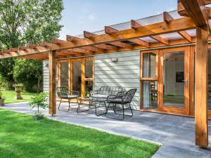 a pergola with a table and chairs on a patio at North Farm Lodges in East Mersea