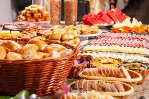 a buffet of food with baskets of bread and pastries at Londres Royal Hotel - Cama de alvenaria in Londrina +10 photos