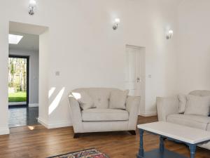 a living room with two chairs and a coffee table at Rose Cottage in Bardon Mill