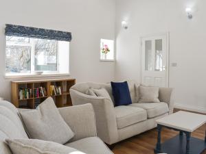 a living room with a couch and a table at Rose Cottage in Bardon Mill
