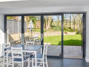a patio with a table and chairs and sliding glass doors at Rose Cottage in Bardon Mill