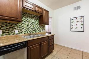 a kitchen with wooden cabinets and a sink at Unit 1 - Modern Roosevelt Row Condo 2BR 1BA Downtown Stay in Phoenix