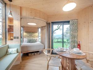 a room with a table and a bed and a window at The Treehouse Caerlaverock - Uk45028 in Carsethorn +9 photos