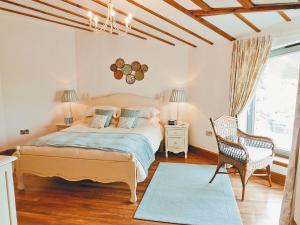 a bedroom with a bed and a chair and a window at Beach Bay Cottage in Mangersta