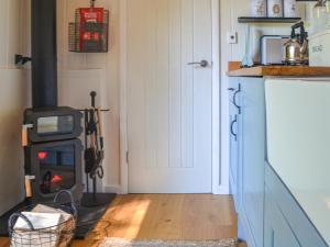 a kitchen with a wood stove in a room at Herdwick Hut Mountain Retreat in Twyn Llanan