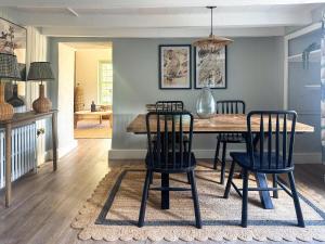 a dining room with a wooden table and chairs at Bluebell Cottage in Bodmin