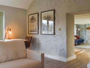 a living room with a couch and pictures on the wall at Bluebell Cottage in Bodmin