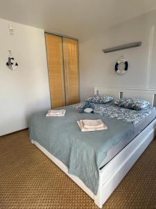 a bedroom with a large bed with two pillows at Taikos 7 in Nida