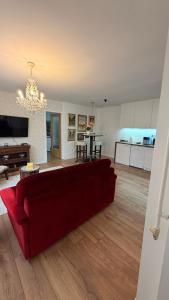 a living room with a red couch and a kitchen at Baklava in Sarajevo