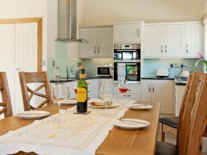 a kitchen with a table with a bottle of wine at Meadow Barn - Blackdown Farm in Blackawton