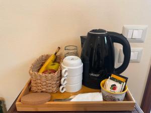 a wooden tray with a tea kettle and a basket of fruit at Agriturismo IL VIAIO in Fiesole