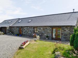 a stone house with a yard in front of it at Ysgubor in Harlech