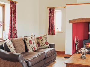 a living room with a brown leather couch at Ysgubor in Harlech