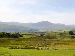a green field with mountains in the distance at Ysgubor in Harlech +7 photos