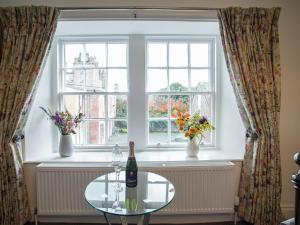 a table in front of a window with a bottle of wine at Stableyard Studio - Uk7173 in Carronbridge