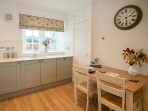 a kitchen with a table and a clock on the wall at Stableyard Studio - Uk7173 in Carronbridge
