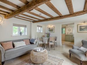 a living room with a couch and a table at Hope Cottage in Ilketshall Saint Andrew