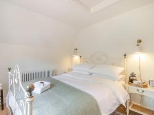 a white bedroom with a white bed with white pillows at Hope Cottage in Ilketshall Saint Andrew +16 photos