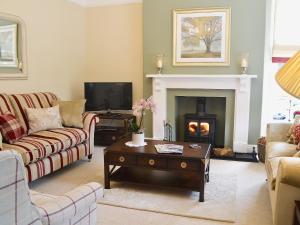 a living room with couches and a fire place at Awelfa - On7 in Aberaeron