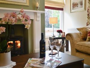a living room with a fireplace and a table with wine glasses at Awelfa - On7 in Aberaeron