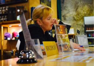 a woman sitting at a counter in a store at Ca la Genoveva in Montsonis