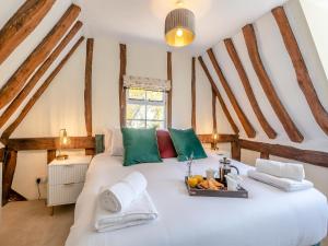 a bedroom with a large white bed with green and red pillows at Oak Tree Cottage in Quidenham