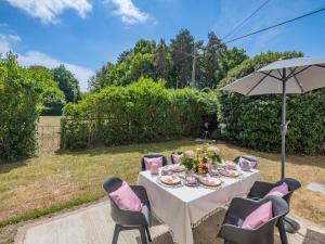 a table with chairs and an umbrella in a garden at Oak Tree Cottage in Quidenham