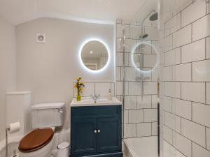 a bathroom with a toilet and a sink and a tub at Oak Tree Cottage in Quidenham +13 photos