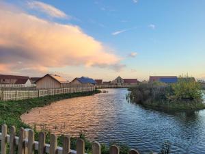 a river with houses and a fence next to it at White Swan Cottage - Ukc4640 in Dunholme