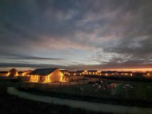 a group of lodges with lights on them at night at White Swan Cottage - Ukc4640 in Dunholme
