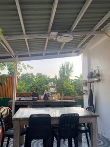 a wooden table and chairs in a patio with a view at Valdez & Ismail HOMESTAY in Apatot